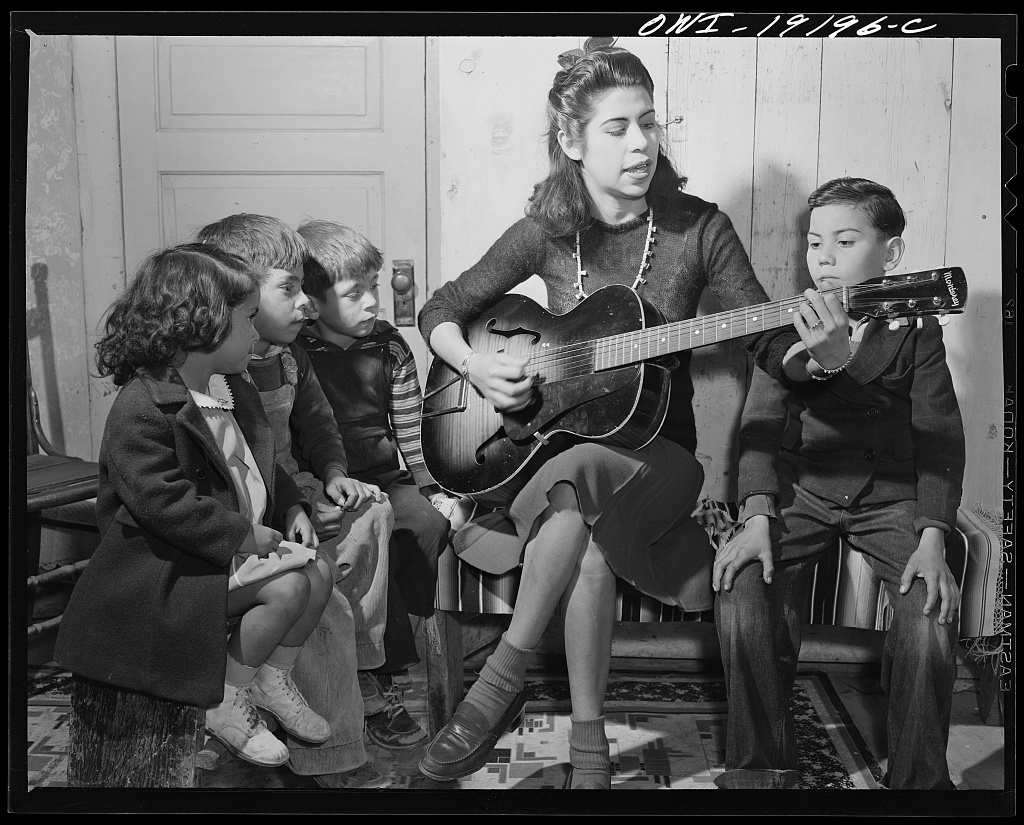 Spanish-American girl singing folk songs to her little brothers and sisters, Albuquerque, New Mexico, 1943. Library of Congress LC-USW3-019196-C.